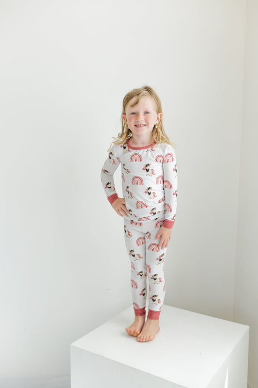Child wearing a pajama set with animal print on a white background