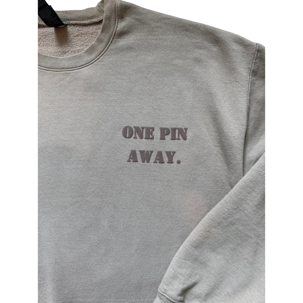 Gray sweatshirt with 'ONE PIN AWAY.' text on a white background