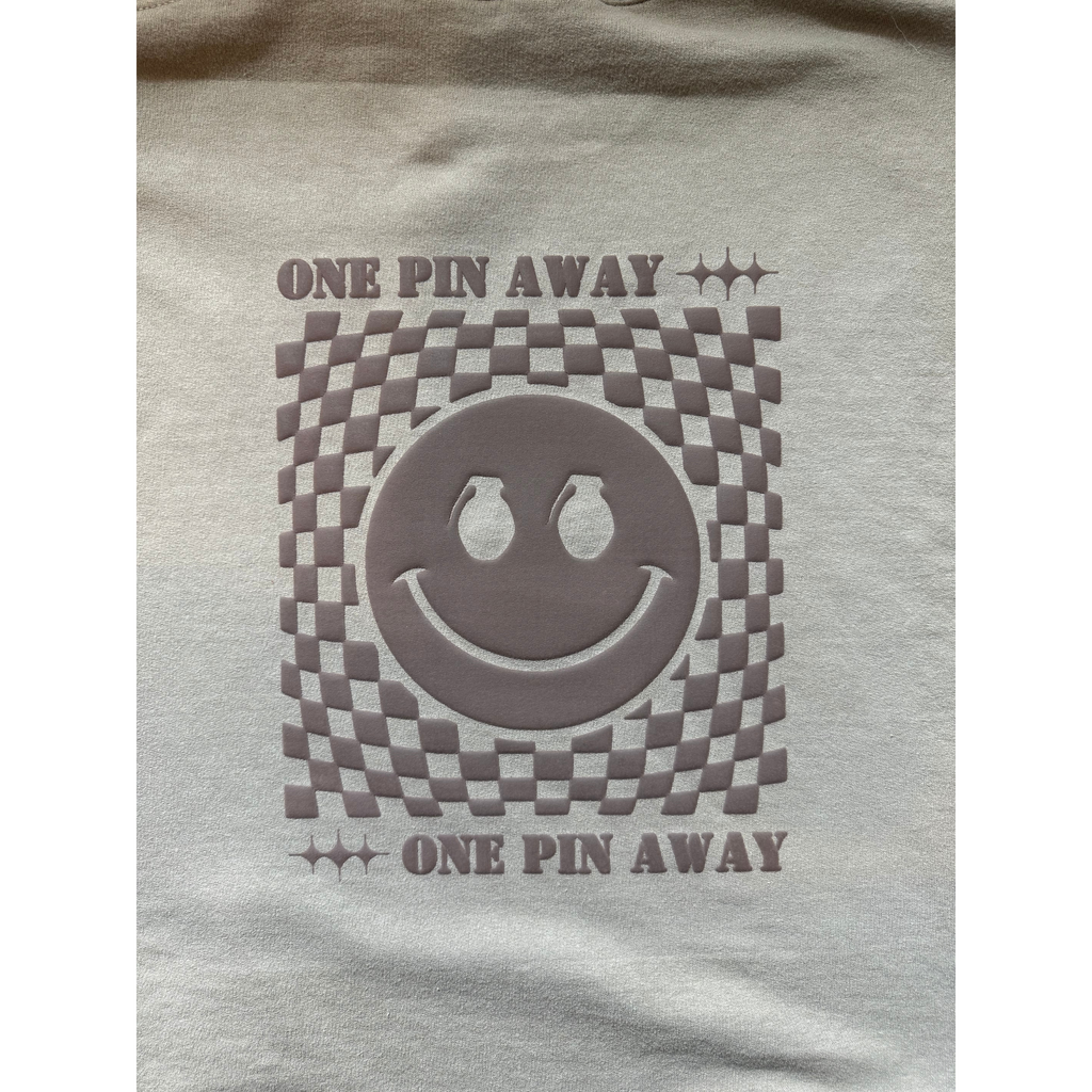 Gray t-shirt with a smiley face design and 'One Pin Away' text on a white background