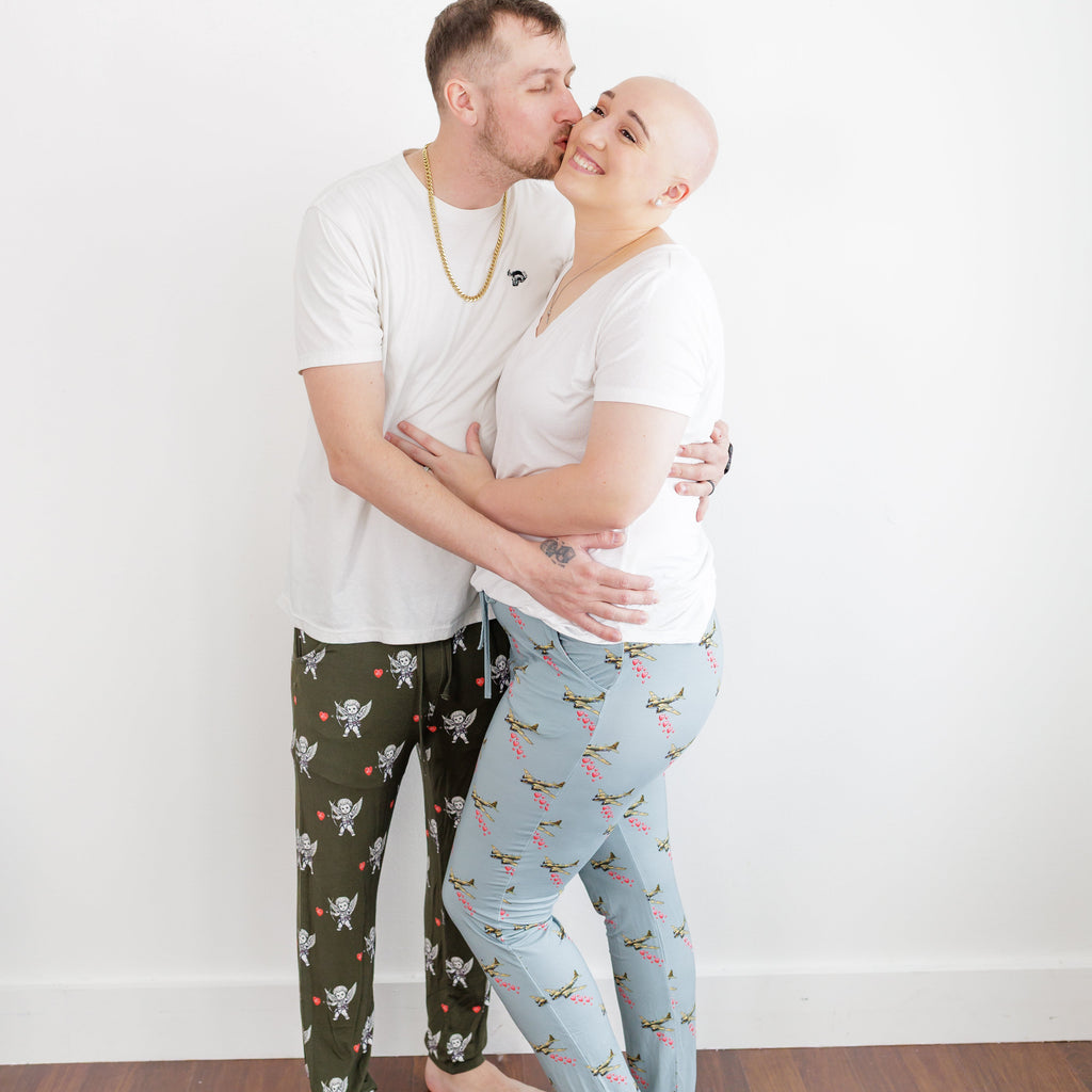 Man and woman embracing on a wooden floor with a white wall background
