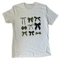 White t-shirt with green and black bow designs on a white background