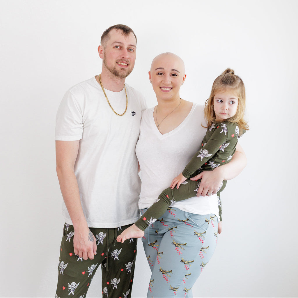 Family of three posing together against a white background