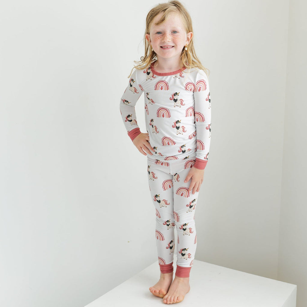 Child wearing a pajama set with animal print on a white background