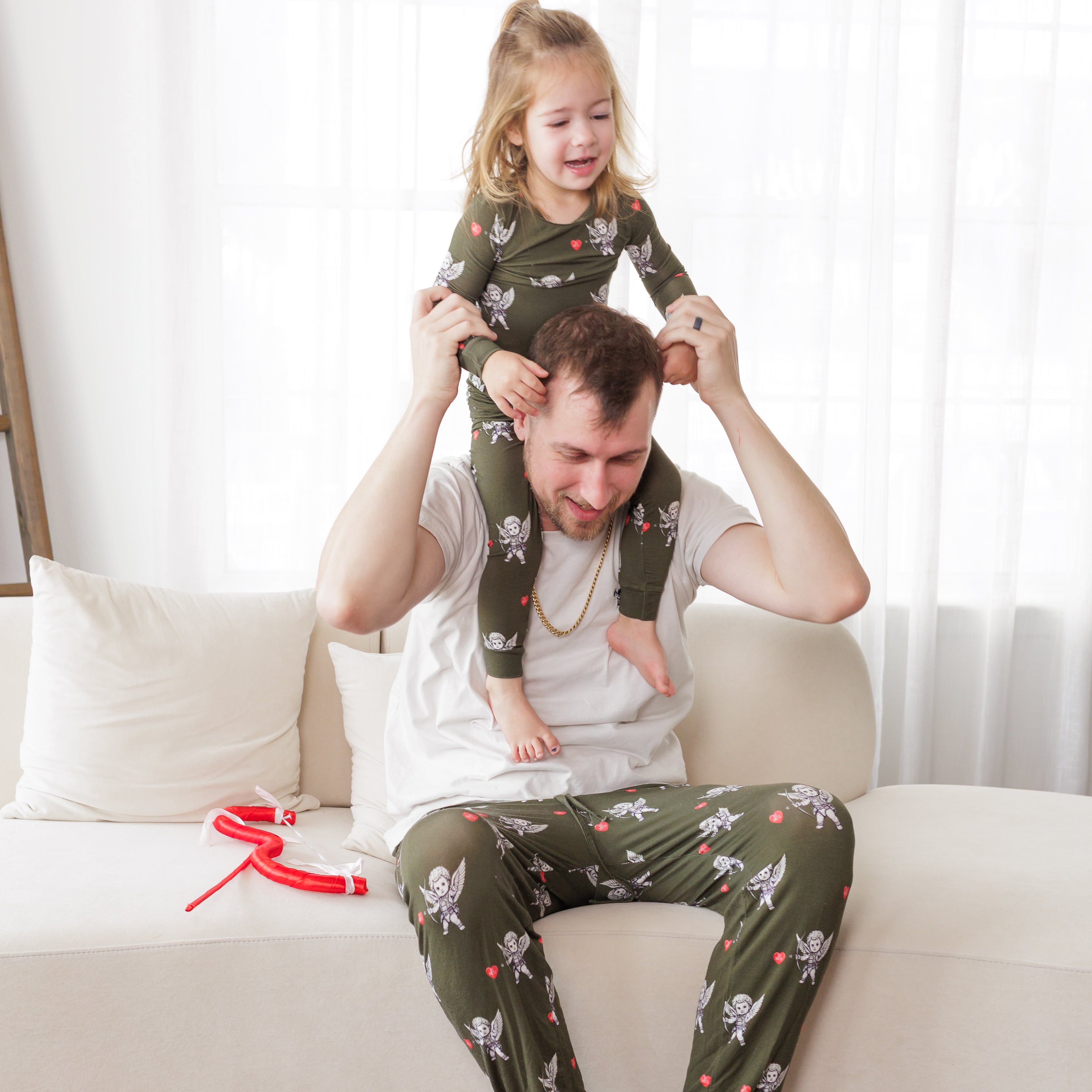 Man and child in matching pajamas sitting on a couch