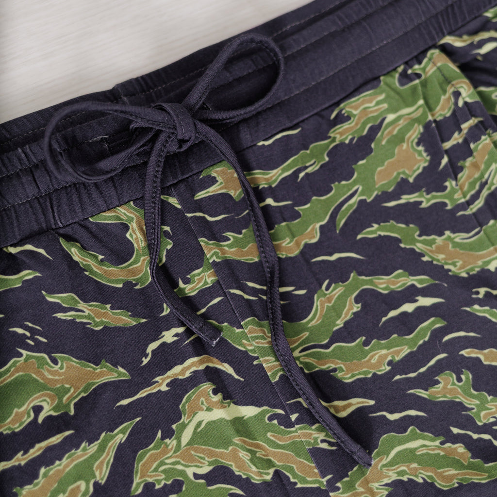 Camouflage-patterned pants with a navy waistband on a white background