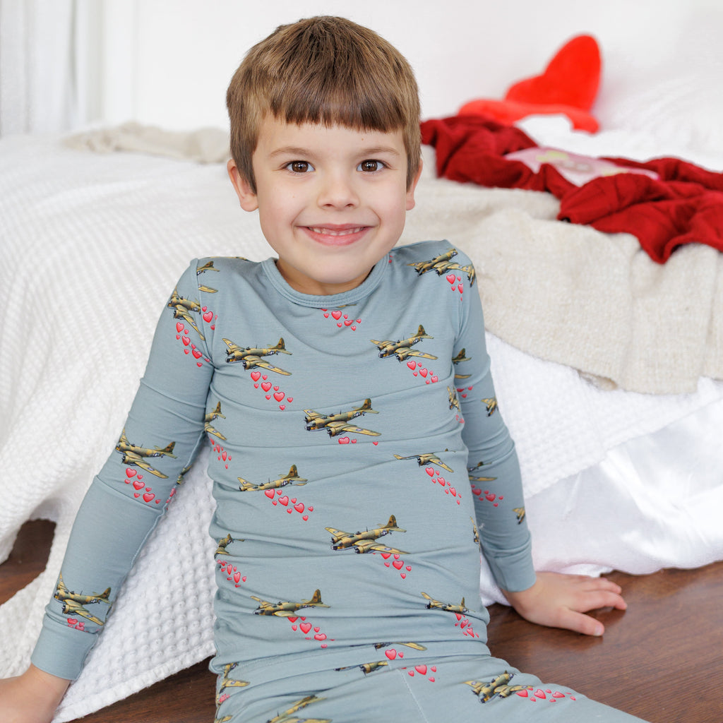 Child wearing a blue long-sleeve shirt with airplane pattern on a white background